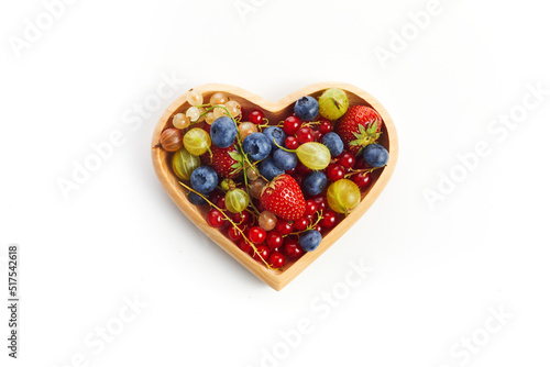 Berries mix in in a heart shaped bowl on white background