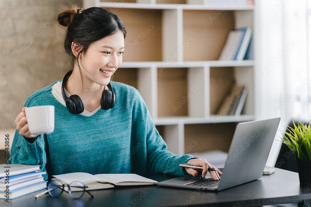 Smart and positive Asian female freelancer or student studying online webinars or courses at home. Video calling and chatting Smart and positive Asian female freelancer or student studying online webinars or courses at home. Video calling and chatting