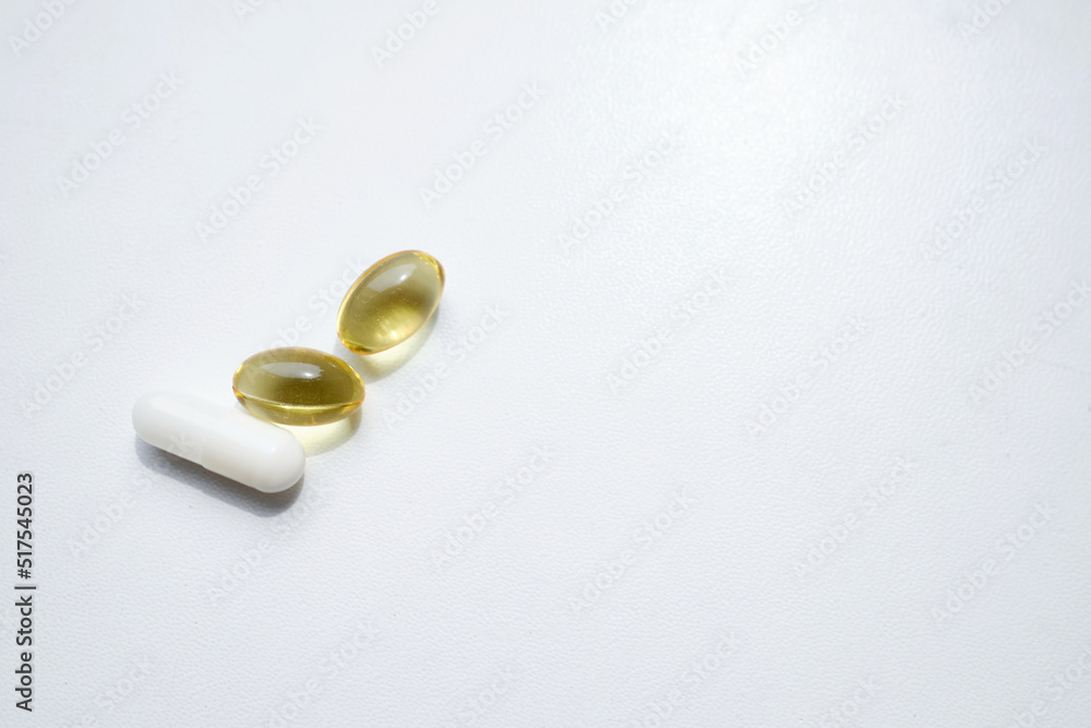 Pill close-up on a white background in a hand. Taking vitamins or medications. The concept of healthcare, medicine, pharmacies, disease prevention Pill close-up on a white background in a hand. Taking vitamins or medications. The concept of healthcare, medicine, pharmacies, disease prevention