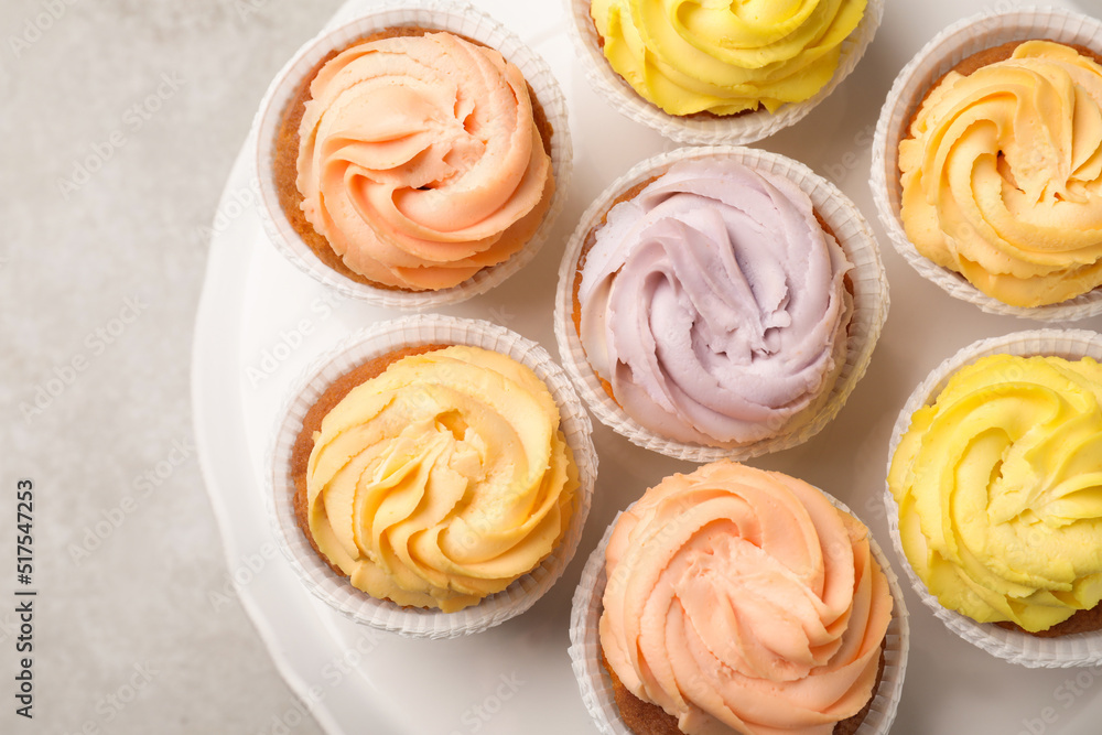 Stand with tasty cupcakes on light table, top view Stand with tasty cupcakes on light table, top view