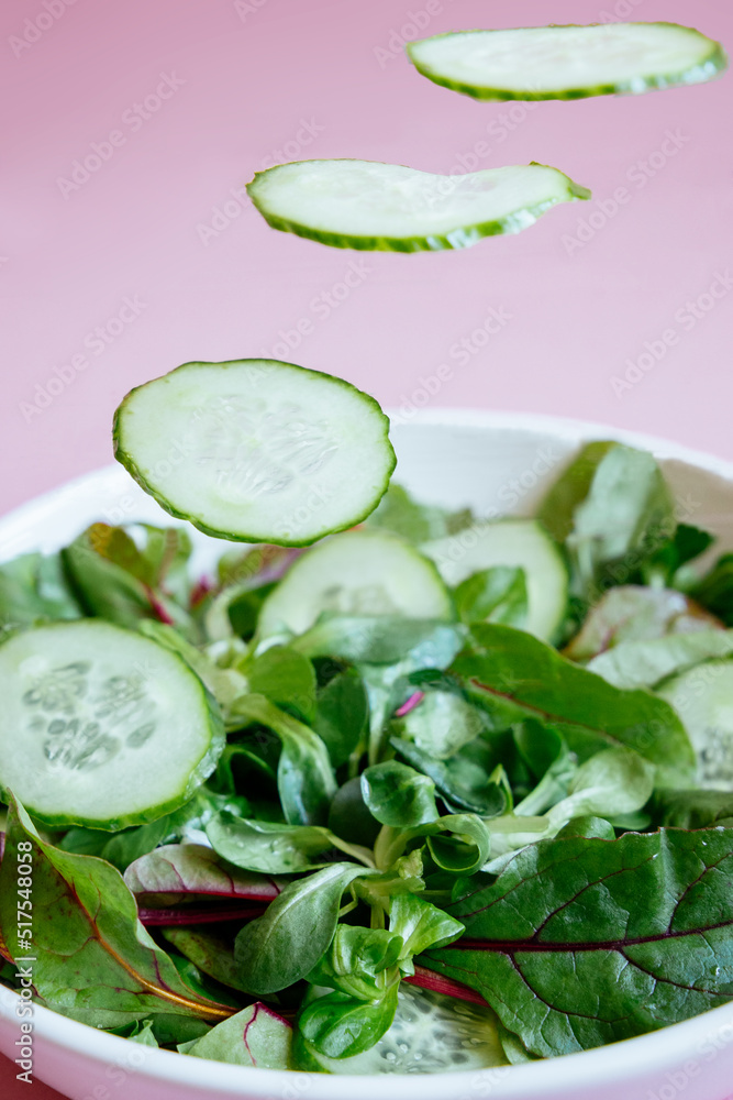 Obraz premium salad levitation with cucumber and lettuce