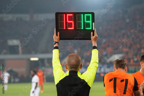 Man shows players substitution during soccer match. photo
