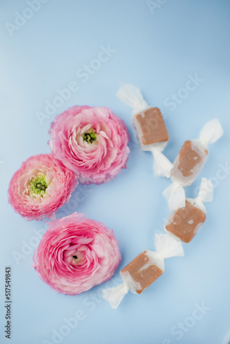 Caramel candies and pink flowers frame
