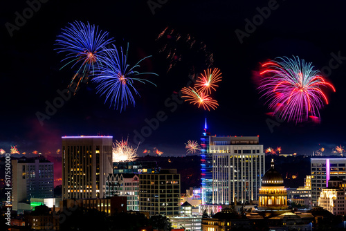 Many fireworks blooming over the Boise skyline at night