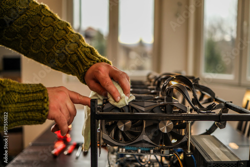 Man wiping cryptocurrency mining rig with rag