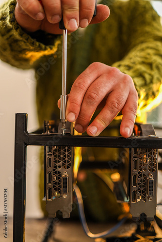 Man using screwdriver for setting up cryptocurrency mining rig at home