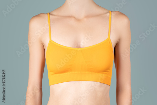 Woman in yellow top bra on gray background photo