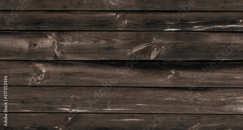 Old Weathered Natural Log Cabin Aged Wall Facade Texture. Rustic Log Wall Horizontal Brown Background. Aged Wall Fragment Of Unpainted Brown Wooden Debarked Logs. Old Barn Wall Wood Wallpaper.