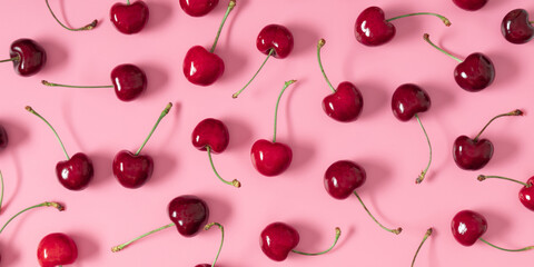Red cherry on pink background. Ripe red cherry berries as background. Flat lay, top view, copy space