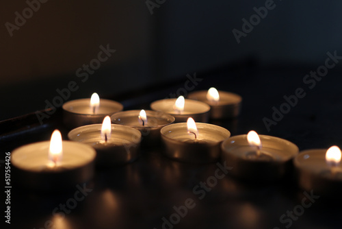 The shape of a cross is laid out from lighted candles.