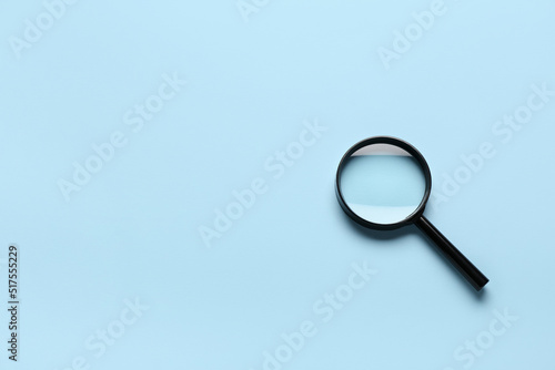 Magnifying glass on light blue background photo