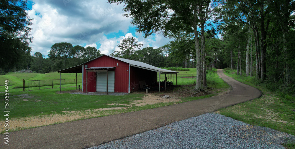 farm land barn and road surrounded by trees farm land barn and road surrounded by trees