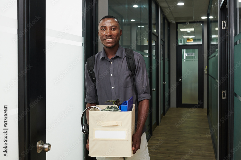 Portrait of happy excited new company employee holding box of his belongigns Portrait of happy excited new company employee holding box of his belongigns
