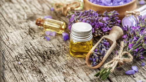 lavender's spa products with dried lavender flowers on a wooden table. Flat lay bath salt and massage oil on wooden background. Skin care, beauty treatment concept. Lavendula oleum