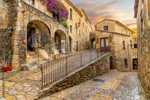 Fototapeta Naklejka Na Ścianę i Meble -  The medieval Spanish village of Pals in the Costa Brava region of Southern Spain as the sun sets after a summer rainstorm.