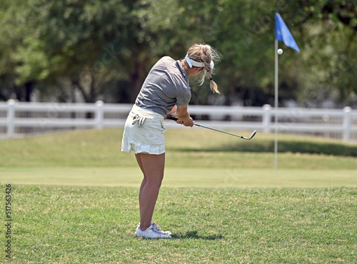 Fotografia Young girl chipping the golf ball on the green during a golf tournament