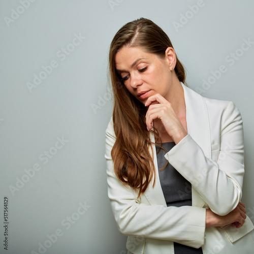 Serious business woman in white business suit looking down. isolated female portrait.