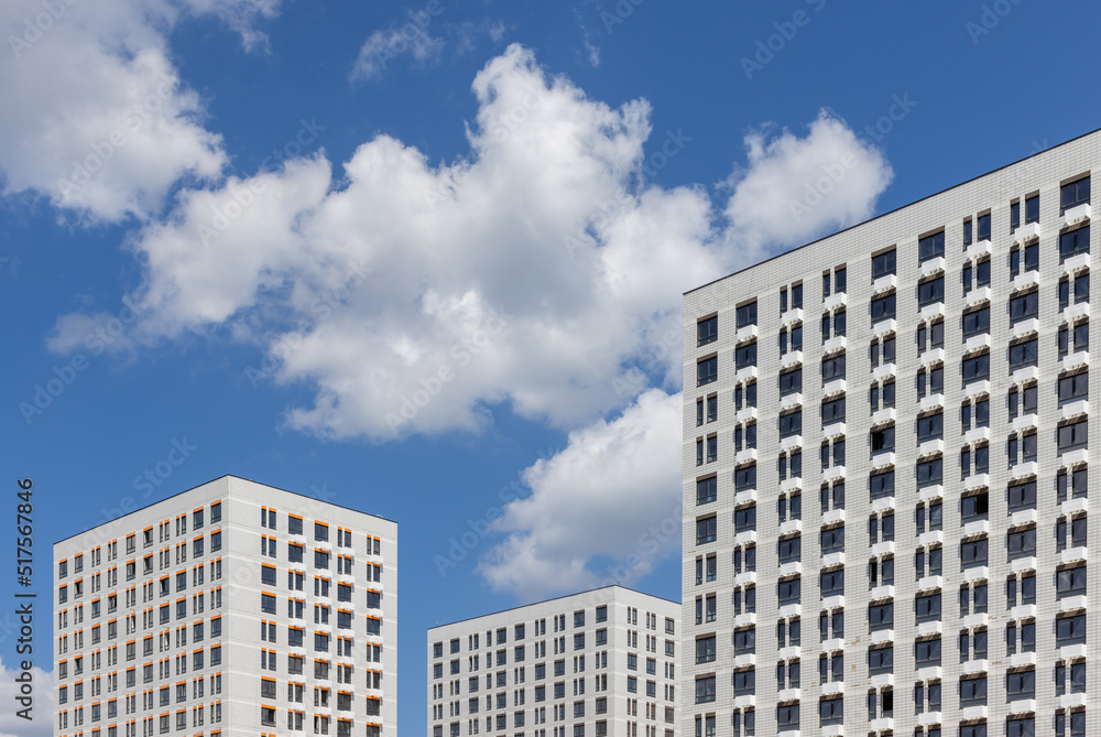 Naklejka premium New modern residential apartment buildings newly build on blue cloudy sky 