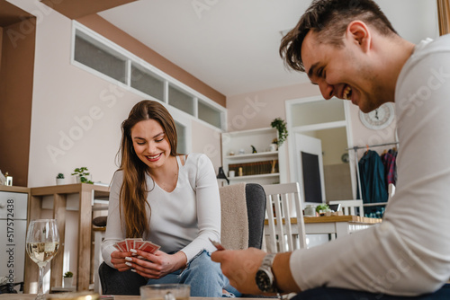 Two people man and woman young couple husband and wife brother and sister or boyfriend and girlfriend playing cards at home in bright day real people leisure games concept having fun copy space