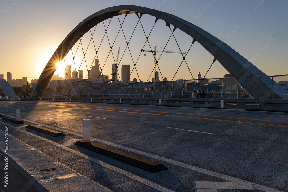 Obraz premium Lens flare at sunset on the 6th street bridge in Los Angeles with the skyline in the distance