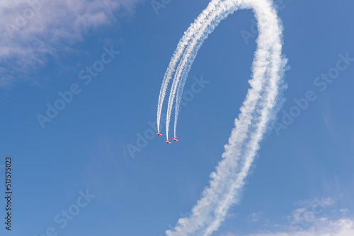 three red planes make a loop in the blue sky