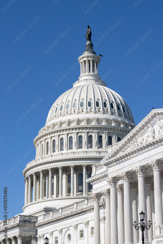 The East Front of the United States Capitol building in Washington, DC, against a clear blue sky.