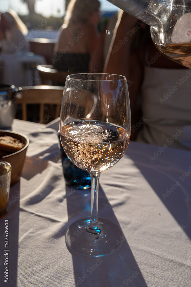Obraz premium Dinner at sunset in French restaurant with cold dry rose wine in Port Grimaud, summer vacation on French Riviera, France