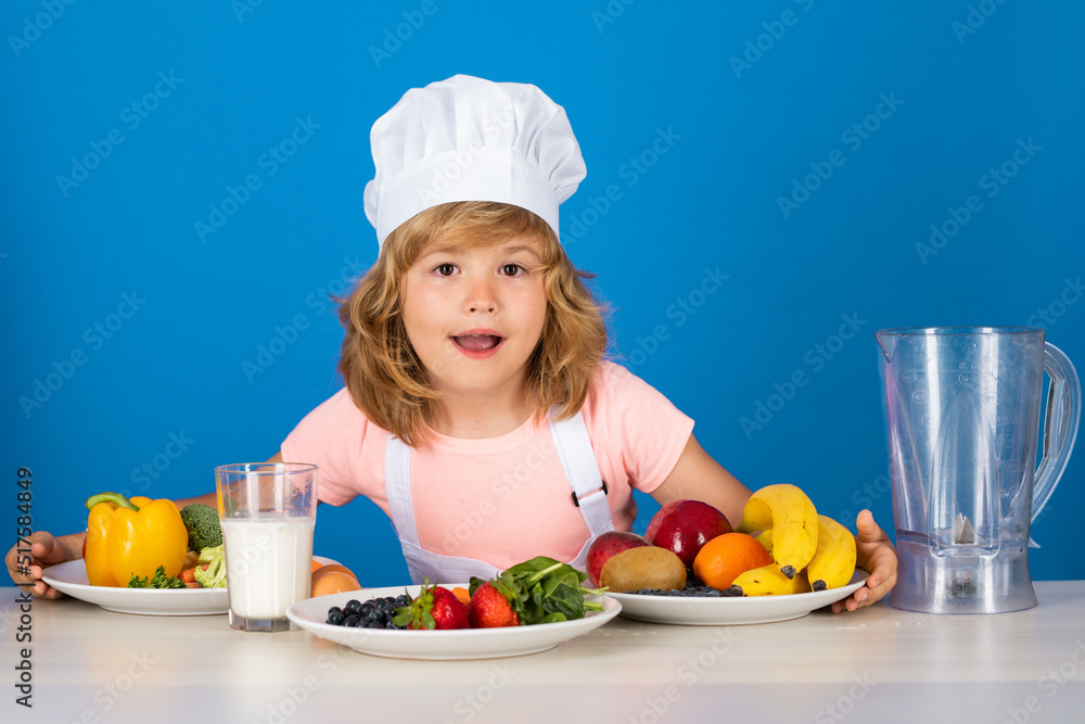 Child chef dressed cook baker apron and chef hat isolated on studio background. Healthy nutrition kids food. Child chef dressed cook baker apron and chef hat isolated on studio background. Healthy nutrition kids food.
