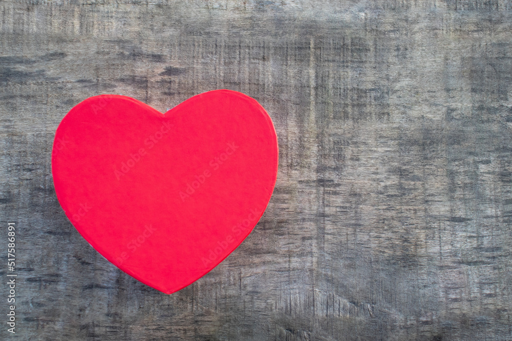Red heart shaped gift box on gray wooden background. Valentinet day, mothers day, birthday celebration concept. Top view, flat lay, copy space Red heart shaped gift box on gray wooden background. Valentinet day, mothers day, birthday celebration concept. Top view, flat lay, copy space