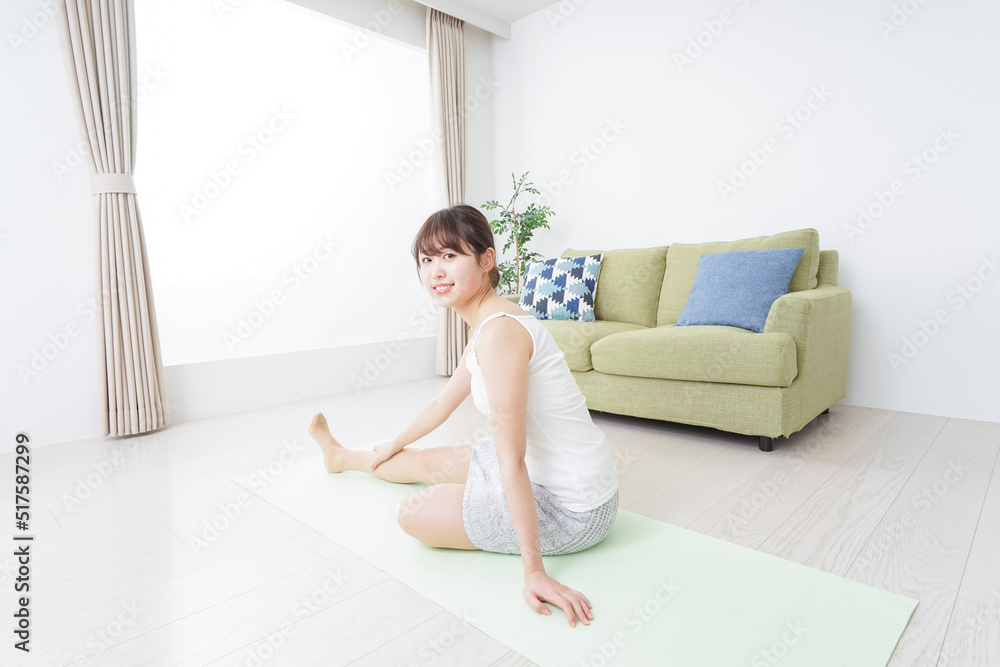 部屋でストレッチをする女性 部屋でストレッチをする女性