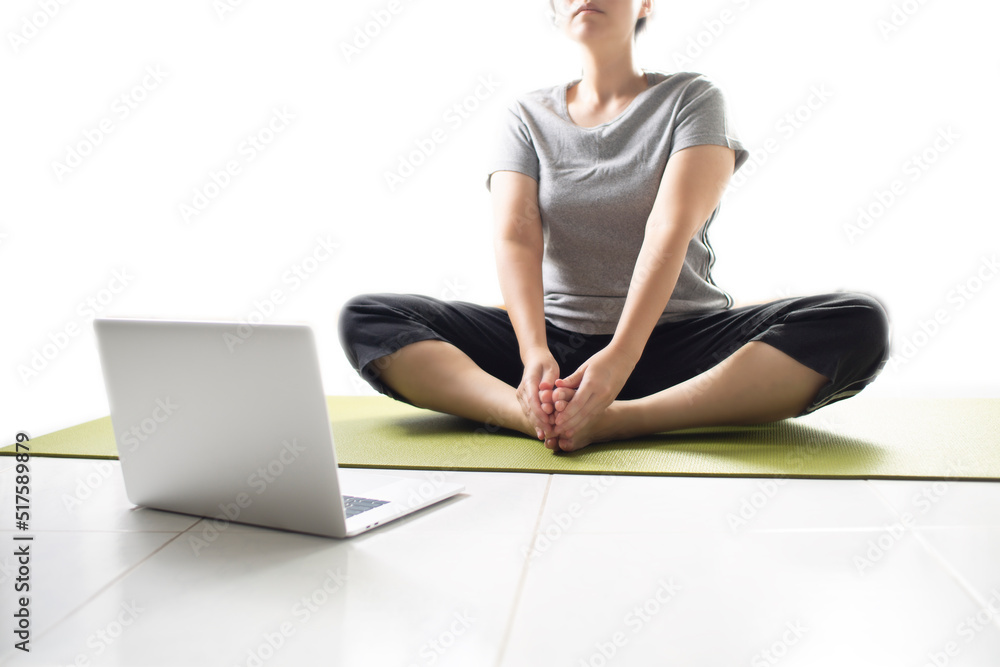 Women using laptop learning yoga at home via yoga online training. Woman studying yoga at home via videoconferencing. women start to practice meditation. Women using laptop learning yoga at home via yoga online training. Woman studying yoga at home via videoconferencing. women start to practice meditation.