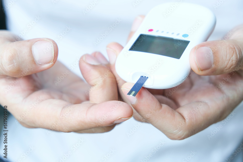 hand of people check diabetes and high blood glucose monitor with digital pressure gauge. Healthcare and Medical concept. hand of people check diabetes and high blood glucose monitor with digital pressure gauge. Healthcare and Medical concept.