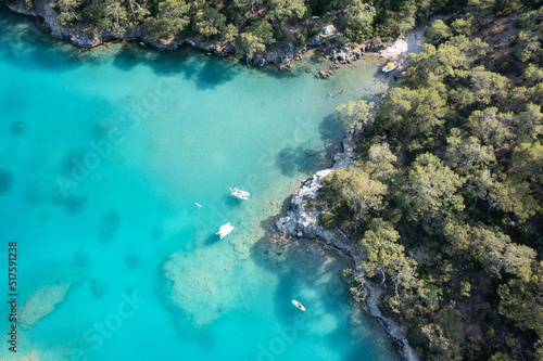 Aerial view on amazing blue sea, rocky beach and small boats. A trip on a boat by the sea in the town of Oludeniz. Active and unforgettable rest in Turkey. 