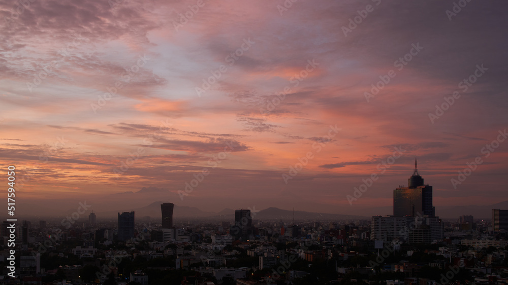 panoramic photo of a beautiful sunrise in mexico city with volcanos in the background (Iztaccíhuatl,  popocatepetl).