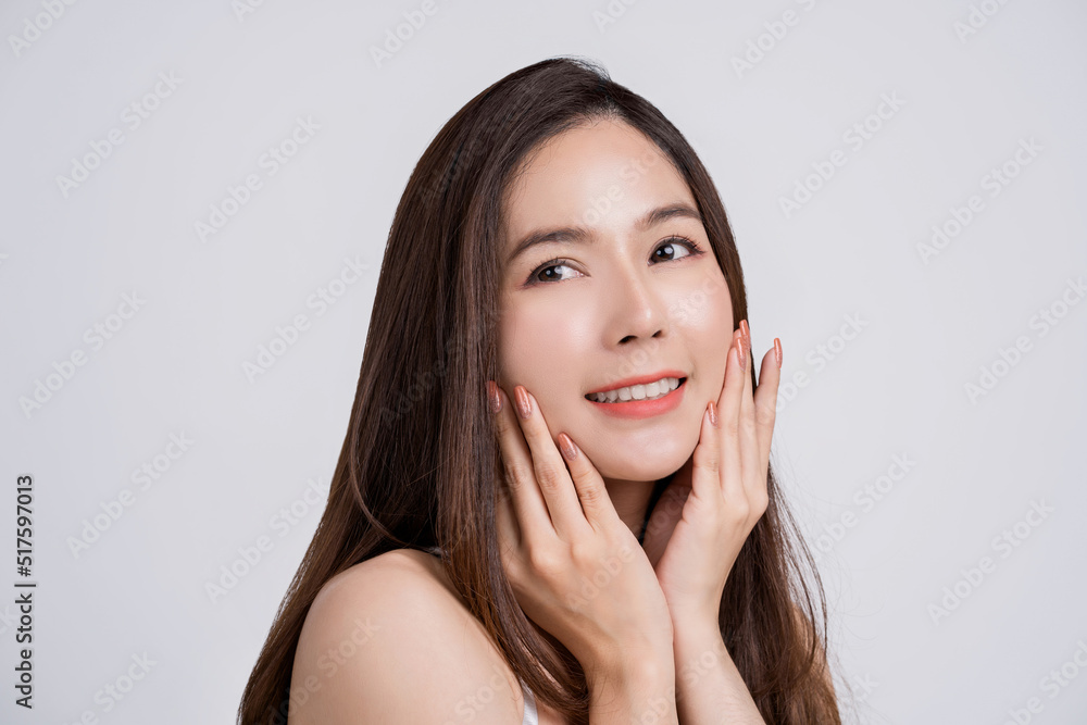 Portrait of an attractive young woman with perfect skin looking out alone over a white background. Portrait of an attractive young woman with perfect skin looking out alone over a white background.