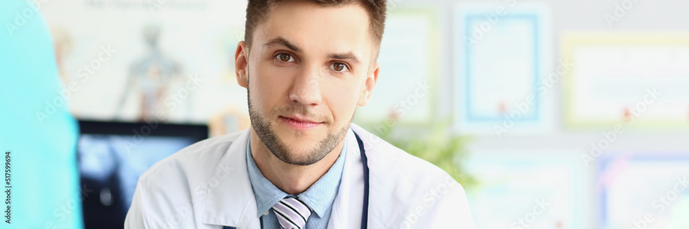 Fototapeta premium Attractive young medical worker in white uniform, wait patient for planned appointment
