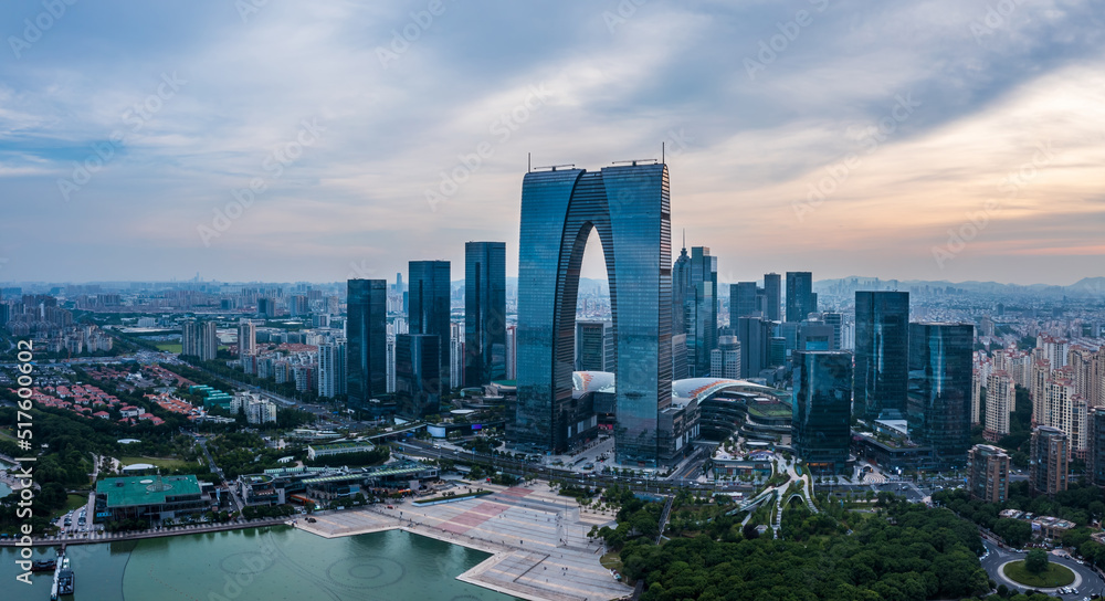 Naklejka premium Aerial view of city skyline and modern commercial buildings in Suzhou at dusk, China.