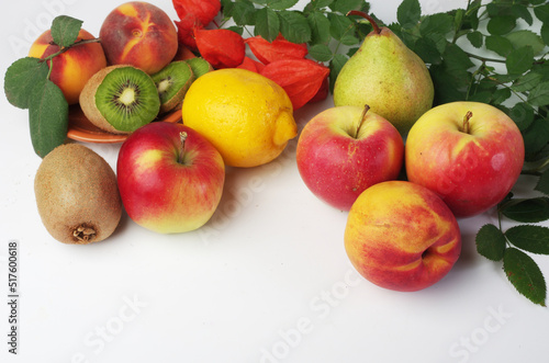 Fresh fruits apples  peaches  kiwi and leaves on a white background.