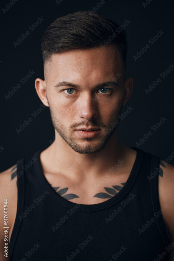 Modelling snapshots. Evil self-confident tanned attractive handsome man in classic suit jacket looks at camera posing isolated in black studio background. Fashion offer. Copy space for ad. Closeup