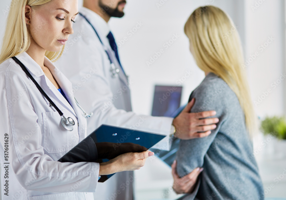 Handsome male doctor consulting a couple about infertility in his medical office Handsome male doctor consulting a couple about infertility in his medical office