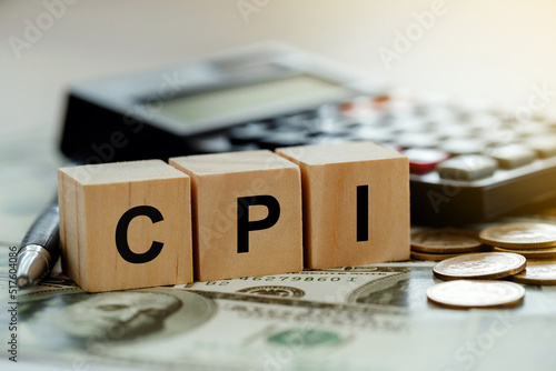 CPI, consumer price index symbol. Wooden blocks with words CPI, consumer price index on dollar bills with a calculator, coins.  Business and CPI, Business and consumer price index concept. photo