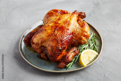 Bild auf Leinwand Homemade Lemon and Herb Rotisserie Chicken on a Plateon a gray background, side view