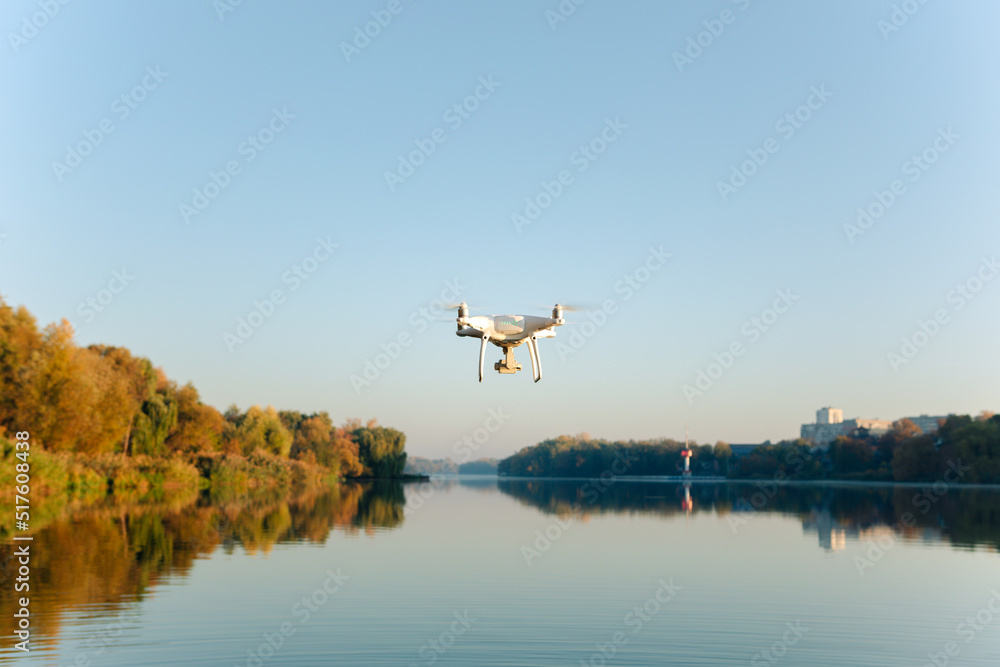Drone copter with digital camera, blur river on background Drone copter with digital camera, blur river on background