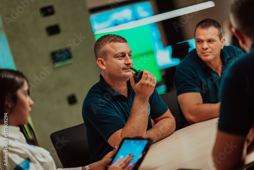 Fototapeta Group of security guards sitting and having briefing In the system control room