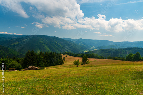 Lomna valley with hills of Moravskoslezske Beskydy mountains above from meadoe nwar Chata Kamenity in Czech republic photo