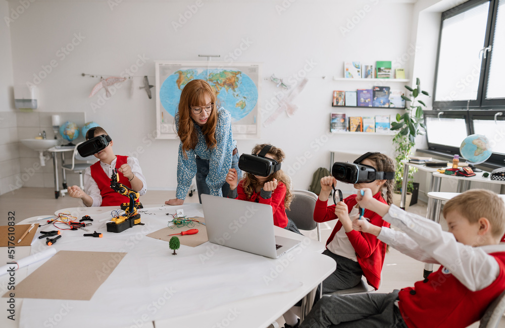 © Halfpoint - Happy schoolchildren wearing virtual reality goggles at school in computer science class