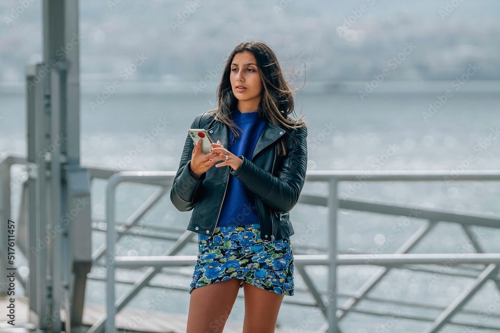 Obraz premium young girl chatting with mobile phone in the port