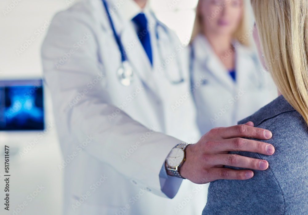 Handsome male doctor consulting a couple about infertility in his medical office Handsome male doctor consulting a couple about infertility in his medical office