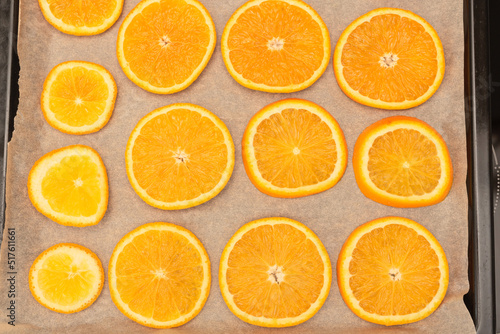 Fresh orange slices on oven tray ready for drying for handmade winter or Christmas decorations. Selective focus