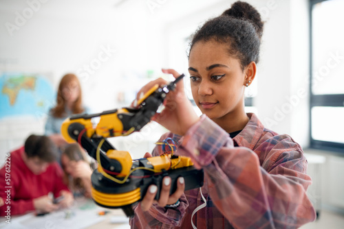 College student holding her robotic toy at robotics classroom at school. photo